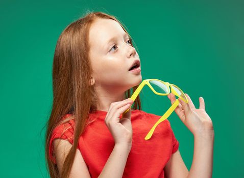 cute girl red hair glasses education school green background. High quality photo