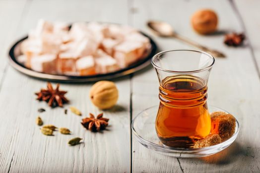 Asian tea in armudu glass with Rahat Lokum and different spices over wooden surface