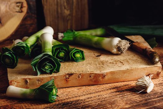 Fresh green leek on cutting board with knife