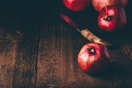 Red pomegranate fruits on rustic wooden surface