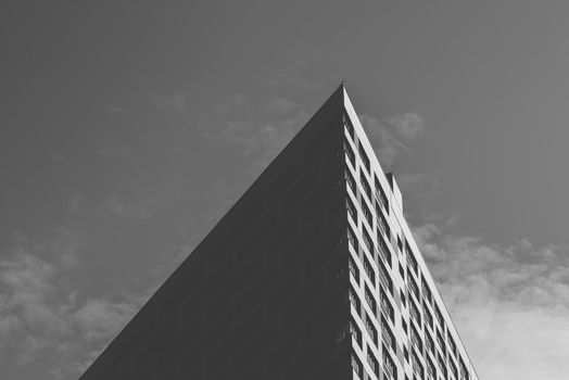 Angle of the Skyscraper on the Cloudy Sky Background. Black and White.