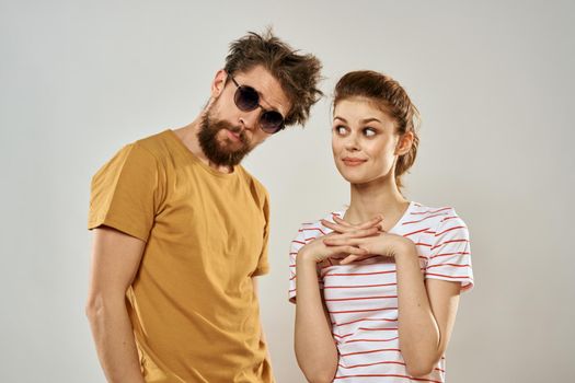 man in sunglasses next to woman in striped t-shirt emotions communication fashion studio fun. High quality photo