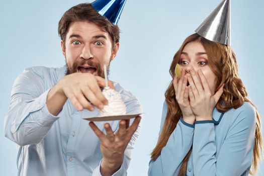 Party man and woman birthday cake corporate fun blue background. High quality photo