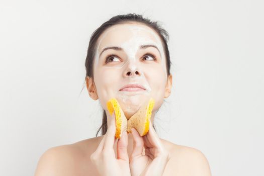 woman with bare shoulders cream mask on face scrub sponges. High quality photo