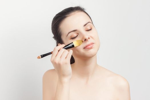 brunette brushing cream on face skin care cropped view. High quality photo
