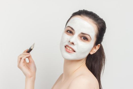 pretty woman applying brush cream on face skin care rejuvenation. High quality photo