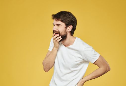 Yellow background model white t-shirt close-up brunette mustache beard. High quality photo