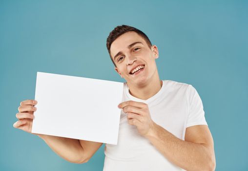 Guy with a white sheet of paper blue background advertising mocap poster. High quality photo