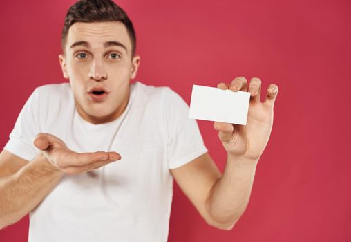 Man gesturing with his hands over red background with business card mockup. High quality photo