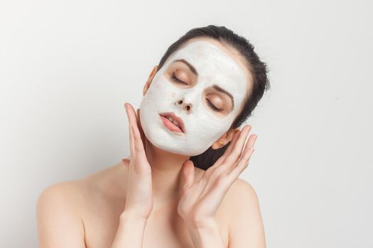 attractive brunette with bare shoulders facial masking skincare. High quality photo