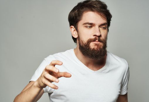 emotional man gesturing with his hands on a light background aggression scream. High quality photo