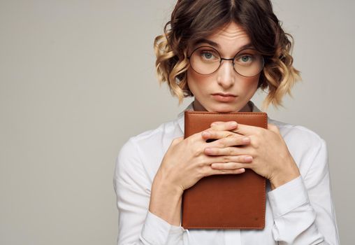 woman on a gray background with a book in her hands and wearing glasses Copy Space. High quality photo
