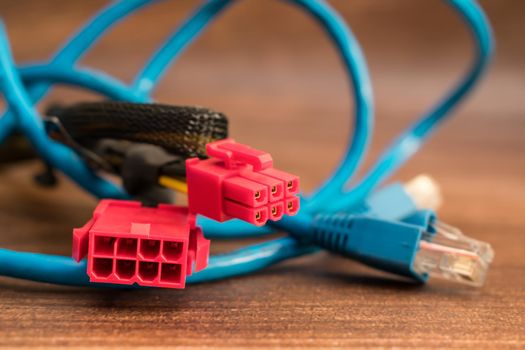 Cables and power connector, as well as a patch cord for the Internet are on the table in the computer workshop