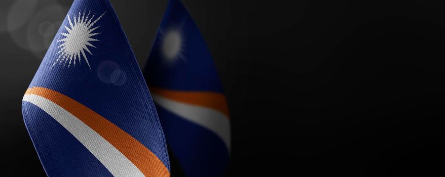 Small national flags of the Marshall Islands on a dark background.