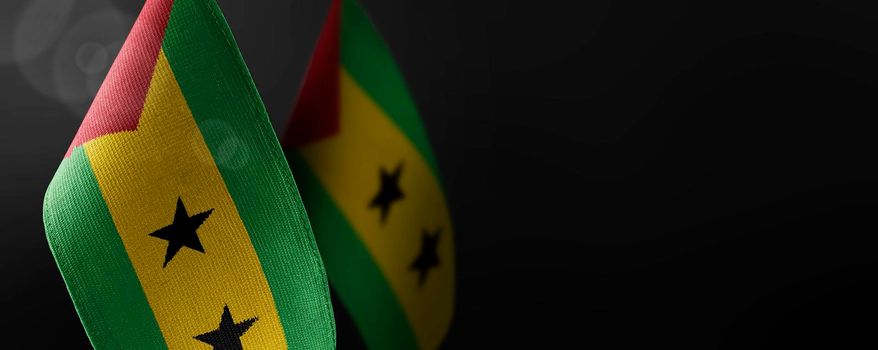 Small national flags of the Sao Tome and Principe on a dark background.