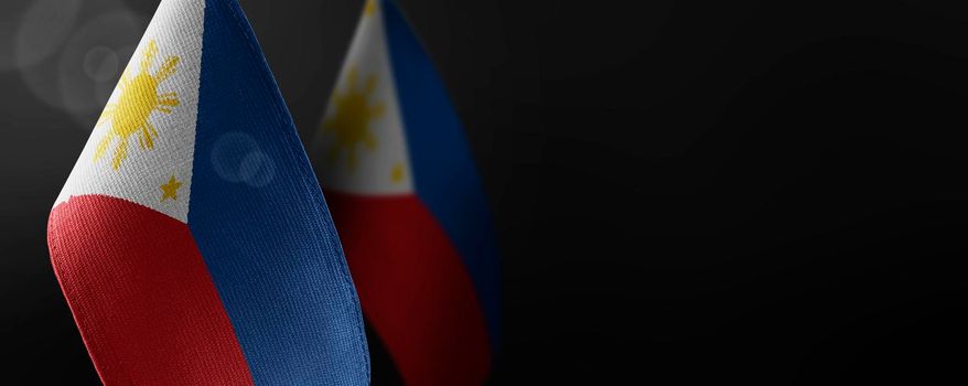 Small national flags of the Philippines on a dark background.