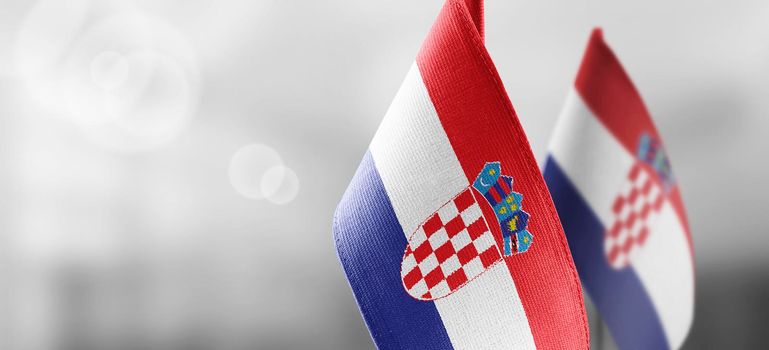 Small national flags of the Croatia on a light blurry background.