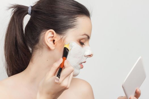 pretty woman with bare shoulders brush in hand skin care applying makeup. High quality photo