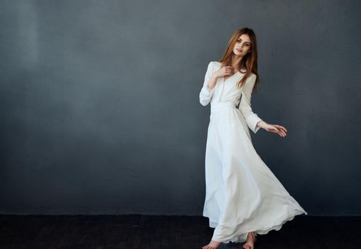 Pretty woman white dress studio performing dance gray background model. High quality photo