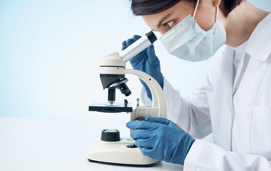 doctors in medical gloves look through a microscope on the table e laboratory chemical element vaccine. High quality photo