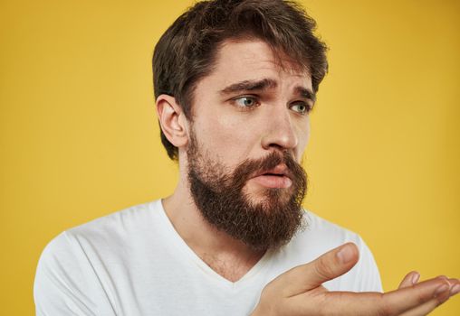 sad man on a yellow background in a white t-shirt beard model. High quality photo