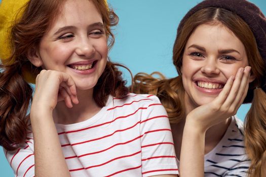 Cheerful mom and little daughter hat fashionable clothes woman joy blue background. High quality photo