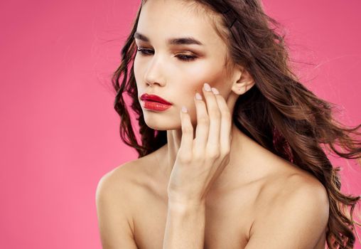 Sexy brunette model pink background red lips bared shoulders. High quality photo