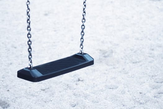 Wooden swing with metal chains for children. No people