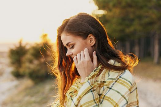 woman near coniferous forest road plaid smile sunset. High quality photo