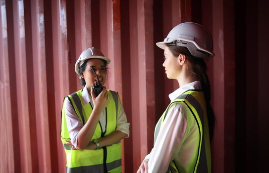 Logistics engineer control at the port, loading containers for trucks export and importing logistic concept