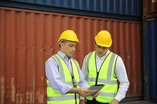 Logistics engineer control at the port, loading containers for trucks export and importing logistic concept