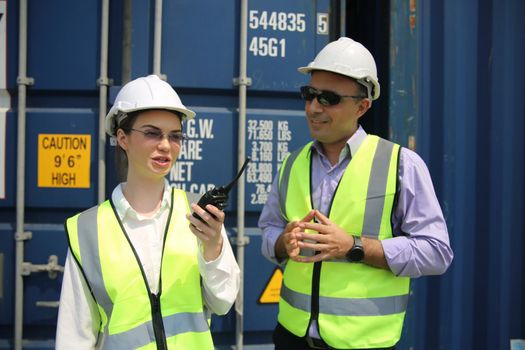 Logistics engineer control at the port, loading containers for trucks export and importing logistic concept