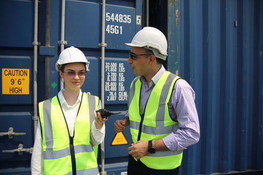 Logistics engineer control at the port, loading containers for trucks export and importing logistic concept