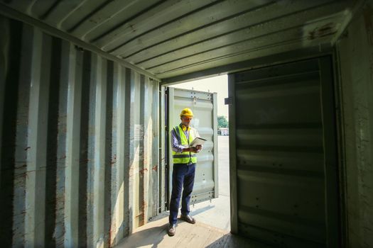 Logistics engineer control at the port, loading containers for trucks export and importing logistic concept