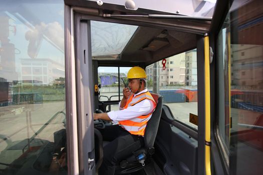 Foreman control loading Containers box from Cargo freight ship for import export. Container Warehouse Worker