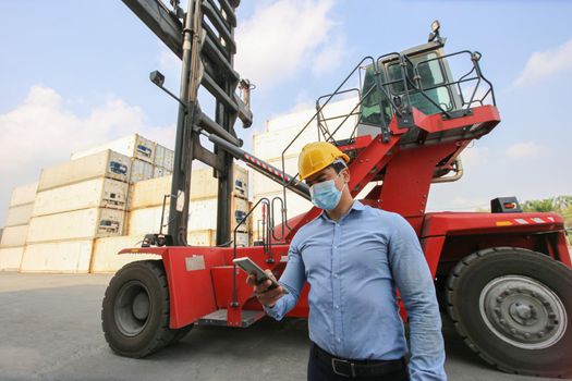 Engineer or supervisor checking and control loading Containers box from Cargo at harbor.Foreman control Industrial Container Cargo freight ship at industry.Transportation and logistic concept. 