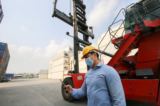 Engineer or supervisor checking and control loading Containers box from Cargo at harbor.Foreman control Industrial Container Cargo freight ship at industry.Transportation and logistic concept. 