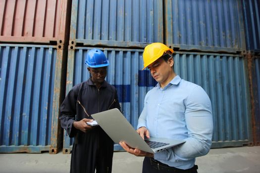 Engineer or supervisor checking and control loading Containers box from Cargo at harbor.Foreman control Industrial Container Cargo freight ship at industry.Transportation and logistic concept. 