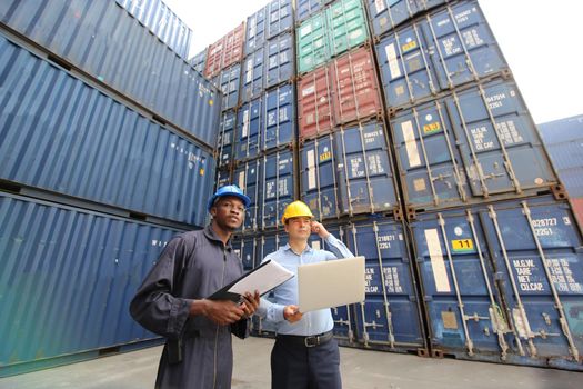 Engineer or supervisor checking and control loading Containers box from Cargo at harbor.Foreman control Industrial Container Cargo freight ship at industry.Transportation and logistic concept. 