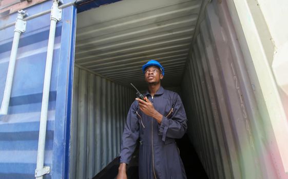 Engineer or supervisor checking and control loading Containers box from Cargo at harbor.Foreman control Industrial Container Cargo freight ship at industry.Transportation and logistic concept. 