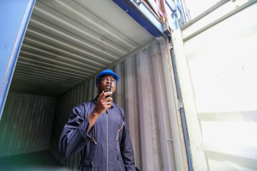 Engineer or supervisor checking and control loading Containers box from Cargo at harbor.Foreman control Industrial Container Cargo freight ship at industry.Transportation and logistic concept. 