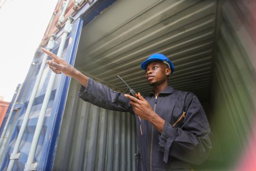 Engineer or supervisor checking and control loading Containers box from Cargo at harbor.Foreman control Industrial Container Cargo freight ship at industry.Transportation and logistic concept. 