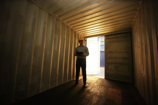 Engineer or supervisor checking and control loading Containers box from Cargo at harbor.Foreman control Industrial Container Cargo freight ship at industry.Transportation and logistic concept. 