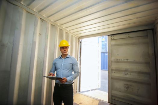 Engineer or supervisor checking and control loading Containers box from Cargo at harbor.Foreman control Industrial Container Cargo freight ship at industry.Transportation and logistic concept. 