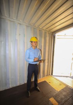 Engineer or supervisor checking and control loading Containers box from Cargo at harbor.Foreman control Industrial Container Cargo freight ship at industry.Transportation and logistic concept. 