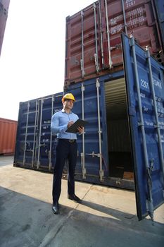 Engineer or supervisor checking and control loading Containers box from Cargo at harbor.Foreman control Industrial Container Cargo freight ship at industry.Transportation and logistic concept. 