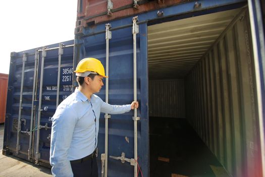 Engineer or supervisor checking and control loading Containers box from Cargo at harbor.Foreman control Industrial Container Cargo freight ship at industry.Transportation and logistic concept. 