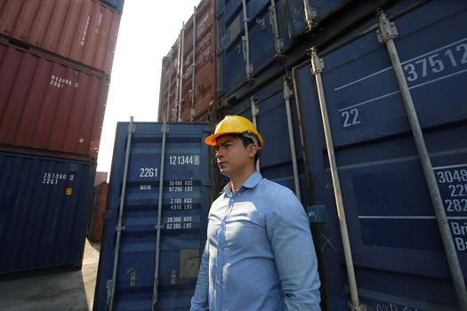 Engineer or supervisor checking and control loading Containers box from Cargo at harbor.Foreman control Industrial Container Cargo freight ship at industry.Transportation and logistic concept. 