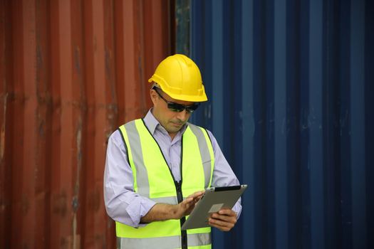 Foreman control loading Containers box from Cargo freight ship for import export.