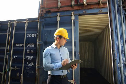 Foreman control loading Containers box from Cargo freight ship for import export.